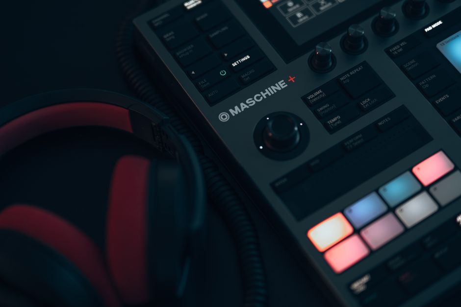 Close-up view of DJ equipment and headphones in a dimly lit room, showcasing music production tools.
